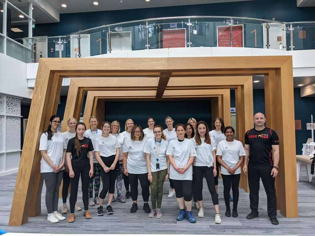 Corporate team practicing Krav Maga self-defence techniques during a workplace safety training session.